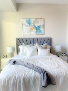 a white bed with white sheets and pillows at The Bleu Oasis in Atlanta