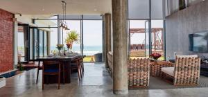 a dining room with a table and a view of the ocean at Abian Kapas Beach House in Tabanan