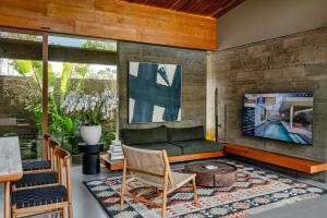 ein Wohnzimmer mit einem Sofa und einem TV in der Unterkunft Domisili Villas Canggu Bali by Fays Hospitality in Canggu