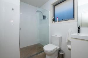 ein weißes Bad mit einem WC und einer Glasdusche in der Unterkunft The Endsleigh -1 Bedroom Villa, Free Wifi, Near CBD in Orange
