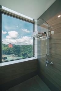 a bathroom with a shower with a large window at Greenview Hotel DaLat in Da Lat