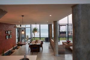 a dining room with a view of the ocean at Abian Kapas Beach House in Tabanan