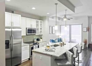a kitchen with a stainless steel refrigerator and white cabinets at Modern Midtown Oasis in Atlanta