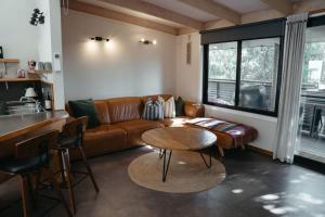 ein Wohnzimmer mit Sofa und Tisch in der Unterkunft The PC Cottage in Port Campbell