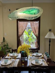 a dining room table with plates and a green at Pao Homes - Riverside House in Hoi An