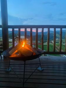 uma mesa numa varanda com uma vela em Chalés Cantinho do Céu em Monte Verde