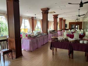 シェムリアップにあるDara Reang Sey Angkor Hotelの紫色のテーブルクロス付きのテーブルが備わる広い客室です。