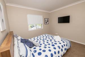 a bedroom with a bed and a flat screen tv at Kinross on Cox Sweet, Neat & Simple + Wifi in Orange