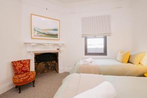 um quarto com 2 camas e uma lareira em Dimby Cottage Beautifully Restored Heritage Home em Orange