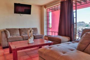 Hotel Chocolate Suites في غواناخواتو: غرفة معيشة مع أريكة وطاولة