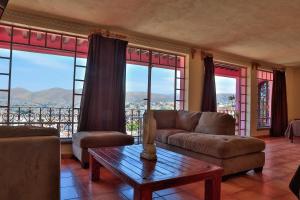 uma sala de estar com um sofá, uma mesa e janelas em Hotel Chocolate Suites em Guanajuato