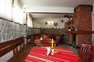 a restaurant with a table and chairs and a fireplace at Aseva House Guest house in Bansko