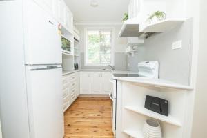 a kitchen with white cabinets and a refrigerator at Sweet Caroline Sunny & Spacious Sleeps 6 in Orange