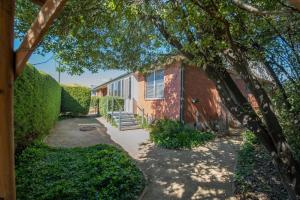 a walkway leading to a brick house with a tree at Sweet Caroline Sunny & Spacious Sleeps 6 in Orange