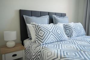 a bed with blue and white sheets and pillows at Sweet Caroline Sunny & Spacious Sleeps 6 in Orange