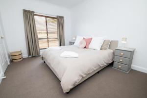 a bedroom with a large white bed with a window at Villa 88 - Stylish, Modern, Fresh & Light in Orange