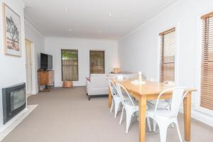 a dining room with a table and chairs and a couch at Villa 88 - Stylish, Modern, Fresh & Light in Orange