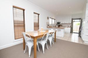 a kitchen and dining room with a wooden table and chairs at Villa 88 - Stylish, Modern, Fresh & Light in Orange +18 photos