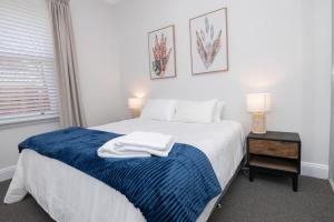 1 dormitorio con 1 cama con manta azul en Dunkley House Bathurst Large CBD Heritage Home, Sleeps 10, en Bathurst