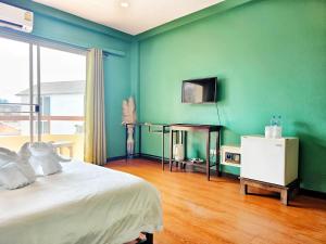 a bedroom with a bed and a green wall at Elegant Lanna Guesthouse in Chiang Mai