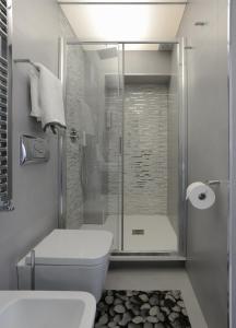 a bathroom with a toilet and a glass shower at Castelfidardo Apartment in Rome