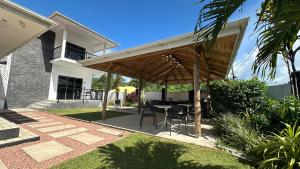patio con tavolo sotto un pergolato in legno di VincVilla a Anse Possession