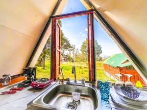 莱瓦镇Glamping Chalet Deluxe cerca al centro de Villa de Leyva - By Serena Morena的大窗户前的厨房水槽