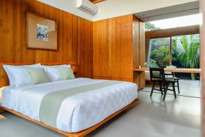 a bedroom with a bed and a table and chairs at Domisili Villas Canggu Bali by Fays Hospitality in Canggu +54 photos