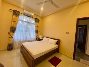 - une petite chambre avec un lit et une fenêtre dans l'établissement WIMAL PALACE, à Jaffna