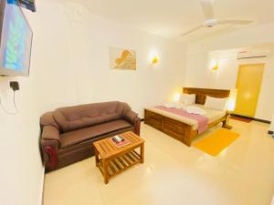 salon z kanapą i łóżkiem w obiekcie Lavinia Blue Hotel w mieście Mount Lavinia