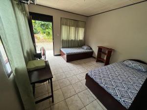 a bedroom with a bed and a desk and a table at Cabinas El Mango in Bribri +25 photos