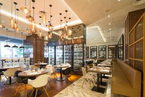 a restaurant with tables and chairs and chandeliers at Amara Singapore - Newly Renovated in Singapore