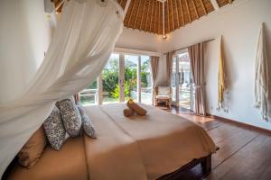 a bedroom with a bed with a mosquito net at Villa Moana Poe Uluwatu in Uluwatu +23 photos