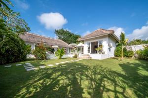 a house with a large yard in front of it at Villa Moana Poe Uluwatu in Uluwatu