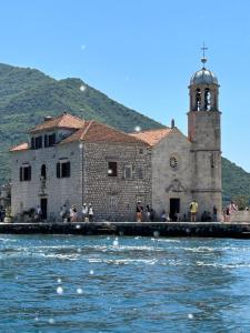 an old building with a clock tower next to the water at Charming apartment in Kotor in Kotor