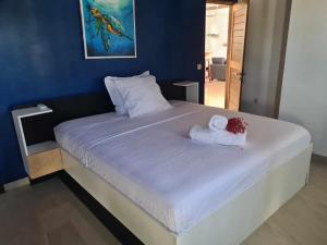 un letto bianco con due asciugamani sopra di Villa Citronnelle a Nosy Be