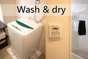 a bathroom with a washing machine with a wash and dry sign at Stay SAKURA Kyoto Shijo Karasuma in Kyoto