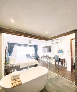 a bathroom with a bath tub and a bedroom at Hoang Gia Hotel Ha Noi Capital in Hanoi