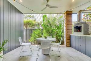 a patio with a table and chairs and a stove at BEIJO DO MAR - your ultimate luxury beach house retreat in Callala Beach