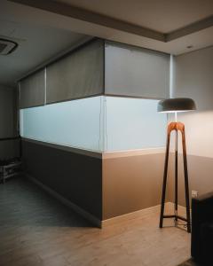 a glass wall in a room with a stool at Magazine Vista Hotel Managed by The Ascott Limited in George Town
