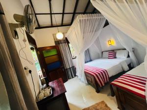 a bedroom with two beds in a room with curtains at Rest Full Homestay in Ella