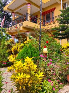 un giardino di fronte a un edificio fiorito di Hotel National Park- A Peaceful Family Home in Sauraha a Chitwan