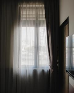 a window with white curtains in a room at Magazine Vista Hotel Managed by The Ascott Limited in George Town +16 photos