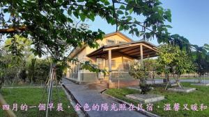 uma casa com um telhado de madeira num parque em Sunny House I em Guilin