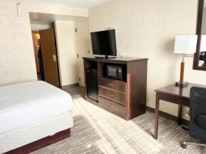 シーダーラピッズにあるKiteville Cedar Rapidsのベッド1台、薄型テレビが備わるホテルルームです。