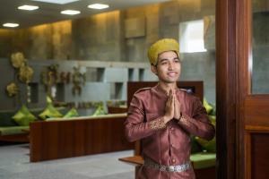 a man standing in front of a door praying at Borei Angkor Resort & Spa in Siem Reap