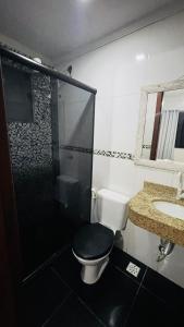 a bathroom with a toilet and a shower and a sink at House Temporada in Búzios