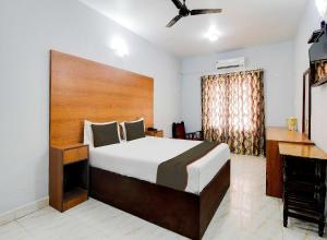a bedroom with a large bed and a desk at Collection O Maizons Lakeview Resort in Arpora