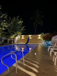 una piscina notturna con sedie accanto di HOTEl LA CANDELARIA ROOM HOUSE a Mangue