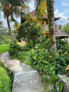 a path leading to a house with a palm tree at Dukuh Village Villas & Art in Tegalalang +27 photos